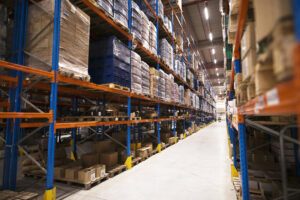 Interior of large distribution warehouse with shelves stacked with palettes and goods ready for the market.