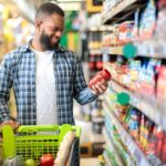 Man Doing Grocery Shopping Standing With Cart Choosing Food Indoors