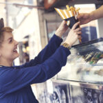 Female customer reaching food from vendor
